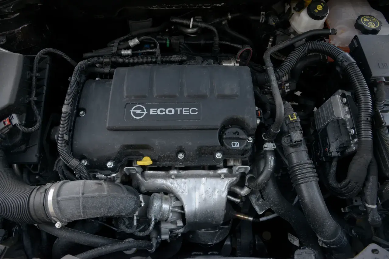 Silnik samochodowy Opel Ecotec z widocznymi przewodami i elementami.