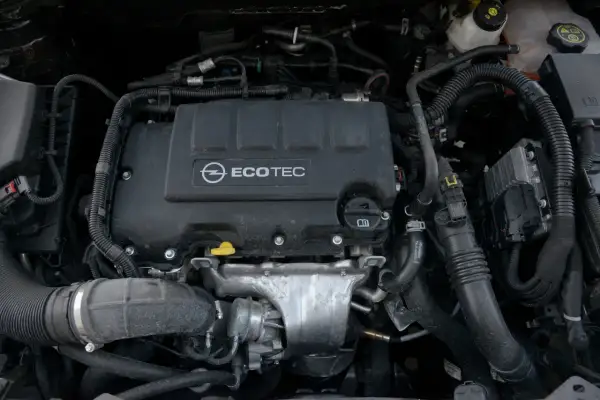 Silnik samochodowy Opel Ecotec z widocznymi przewodami i elementami.